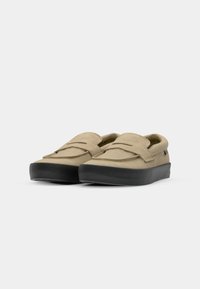 Barna nubukbőr slip-on cipők, lekerekített orral, réteges elülső füzőkkel és vastag fekete gumitalppal.