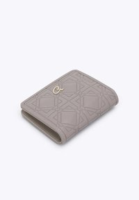 Cartera de cuero gris con patrón geométrico en relieve y pequeño cierre dorado, doblada y descansando sobre una superficie blanca.