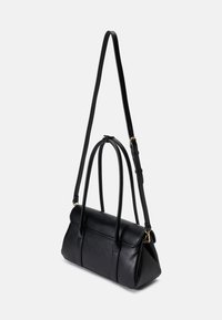 Černá kožená kabelka se strukturovaným tvarem, dvěma krátkými uchy a nastavitelním dlouhým popruhem. Obsahuje minimální kovové detaily a má hladkou texturu.