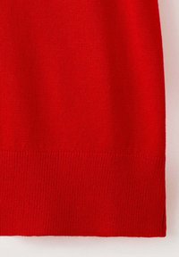 Tissu tricoté rouge avec un ourlet côtelé, montrant la texture et les détails des points sur un fond clair.