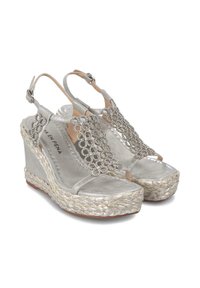 Sandalias de cuña plateadas con correas decorativas de cuentas, que cuentan con una plataforma de yute trenzado y una correa de tobillo ajustable. Acabado suave de satén.