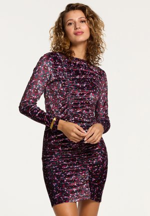 Purple velvet dress with long sleeves, ruched design, and colorful floral pattern. Features a fitted cut and side slit.
