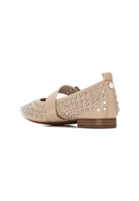 Zapato plano de cuero marrón con tacón plano, adornado con piedras brillantes en un lado y una tira cruzada en el empeine. Textura suave, diseño de punta afilada.