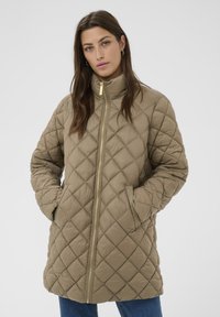 Genähte, hellbraune Jacke mit einem hohen Kragen, Reißverschluss und zwei Seitentaschen. Verfügt über eine glatte Textur und goldene Hardware-Details.