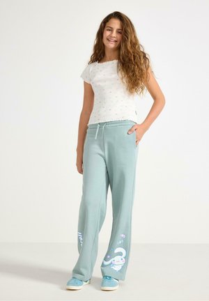 Lichtblauwe sweatpants met een relaxte pasvorm, met een witte konijnafbeelding en pastelkleurige accenten. Gecombineerd met een witte top met korte mouwen met patronen.