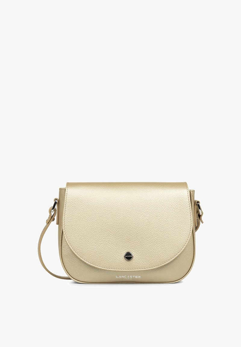 Sac bandoulière en cuir beige avec rabat arrondi, surface texturée, accents en métal noir, bandoulière ajustable et logo de la marque embossé à l'avant.