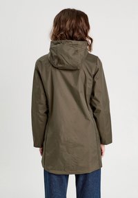 Veste de pluie résistante à l'eau, couleur vert olive, avec capuche, manches longues et ourlet légèrement courbé. Texture lisse et détails matériels minimaux.