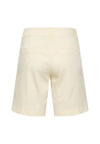 Světlé žluté šortky vyrobené z bavlny, s rovný střih, dvěma zadními kapsami a čistým lemem. Minimalistický design bez viditelných log.