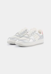 Sneakers metallici argento con una superficie liscia, dettagli bianchi, punta perforata e un particolare tacco rosa, dotati di una suola in gomma.