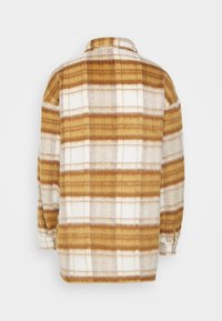 Camisa de franela a cuadros en tonos cálidos de marrón y crema, con cuello, mangas largas y un ajuste relajado con un dobladillo recto.