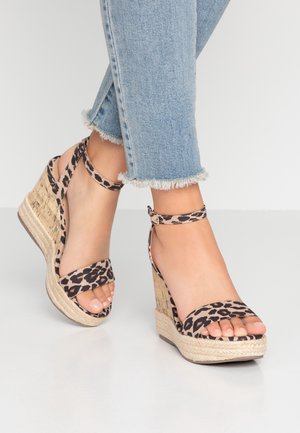 Sandály na wedges s leopardím potiskem a espadrilovou podrážkou. Popruhy jsou vyrobeny z měkkého materiálu, s přírodně texturovaným podpatkem a otevřenou špičkou.