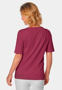 Bordeaux kortemouwen t-shirt met een ronde hals, een gladde stoftextuur en een ontspannen pasvorm, vanuit de achterkant gezien.