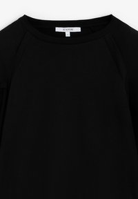 Musta pitkähihaisuus pusero, joka on valmistettu sileästä kankaan, jossa on pyöreä pääntie ja raglan-hihat. Tuotteessa on etiketti, joka osoittaa koon S.