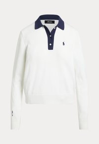 Chemise polo blanche à manches longues avec col bleu marine, dotée d'une patte de boutonnage à trois boutons et d'un petit logo brodé sur la poitrine gauche.