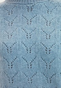 Hellblauer gestrickter Pullover mit einem strukturierten Muster aus Pfeilen und leichten braunen Akzenten, einem gerippten Kragen und einem weichen, warmen Erscheinungsbild.