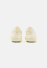 Lekkie sneakers w kolorze kremowym z teksturowaną siateczką oraz minimalistycznym designem. Posiadają wyściełany tab z tyłu dla wsparcia.