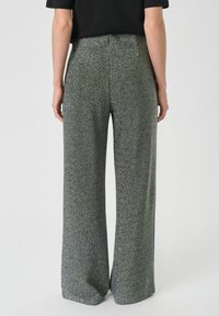 Weite Hose aus strukturiertem, metallischem grauem Stoff. Verfügt über eine hohe Taille und einen sauberen Abschluss, der eine elegante Silhouette bietet.