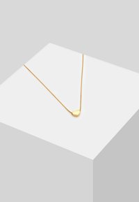 Guld vedhængsarmbånd med et hjerteformet charms på en fin kæde. Metallet har en poleret overflade og en glat tekstur.