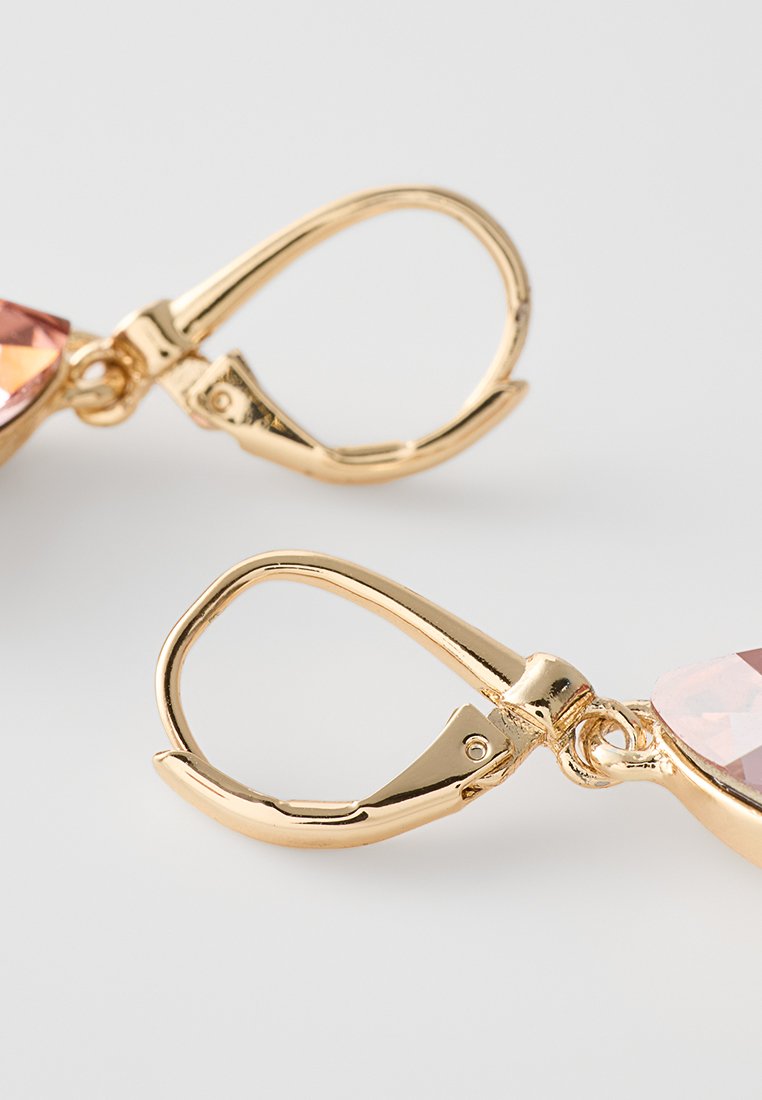 Ohrringe in Goldfarbe mit einem Klappverschluss und einem rosa, facettierten Stein mit glatter Oberfläche in tropfenförmigem Design.