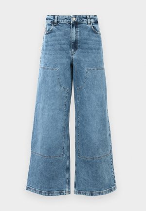 Lyseblå denim bukser med vid ben og høj talje, store frontlommer og synlige stikninger. Har et klassisk fem-lomme design.