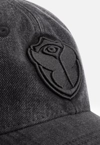 Zwarte baseballpet met geborduurd logo in een tonale design. De stof heeft een zachte textuur met een klassieke gebogen klep en een veilige verstelbare band.