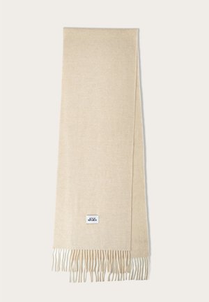Sciarpa beige realizzata in tessuto morbido, con bordi frangiati e un piccolo etichetta quadrata del marchio in blu e bianco.