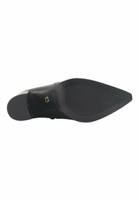Black pump shoe with a pointed toe and a narrow heel. Made of smooth material with a textured rubber sole featuring horizontal grooves.