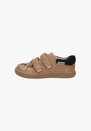Sneaker per bambini color tan con due cinghie in Velcro regolabili, colletto del tallone imbottito di colore nero e dettagli di cucitura sottili, vista laterale su sfondo bianco.