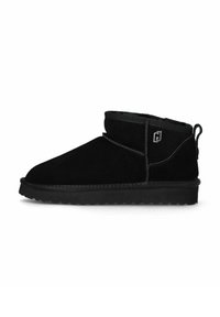 Bota de ante negra de tobillo con suela de goma plana, costuras decorativas, logo de metal en el costado y asa en el talón.