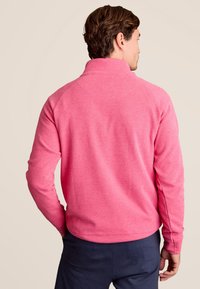 Roze fleece pullover met een hoge kraag, lange mouwen en een relaxed fit. Heeft een zachte textuur en ribbelafwerking bij de kraag.