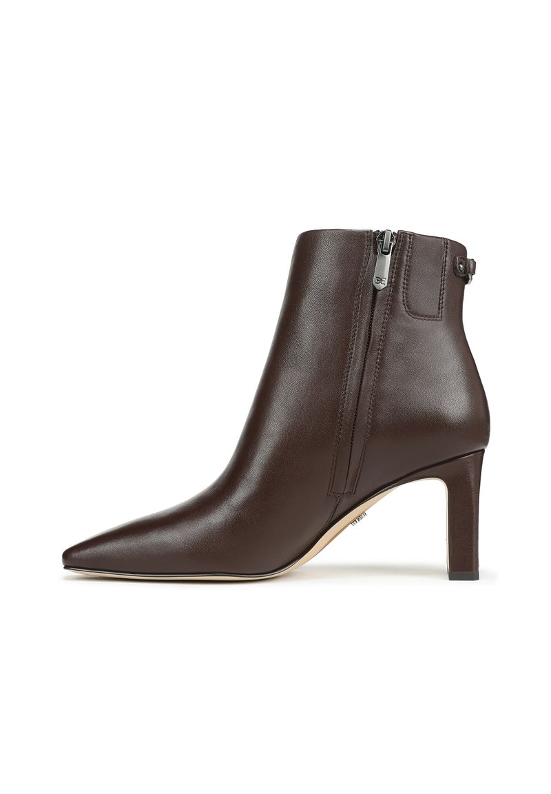 Bottine en cuir marron avec un bout pointu, un talon fin et une fermeture éclair sur le côté, présentant une texture lisse et un design minimaliste.