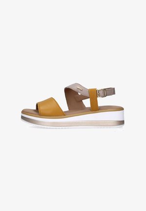 Sandali gialli e beige con punta aperta, dotati di due fasce e una fibbia. Una suola a piattaforma bianca e oro metallico aggiunge altezza.