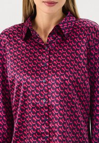 Blusa di seta con motivo astratto rosa e blu navy, colletto classico, chiusura frontale a bottoni e superficie liscia.