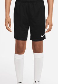 Schwarze Sportshorts mit einem elastischen Bund und seitlichen Eingrifftaschen, mit einem weißen Nike-Swoosh-Logo am linken Saum. Weiße kniehohe Socken.