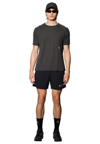 Męski strój sportowy składający się z ciemnoszarego t-shirtu, czarnych szortów, czarnych skarpetek z białymi akcentami oraz czarnych butów, uzupełniony czapką i okularami przeciwsłonecznymi.