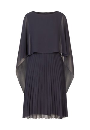 Plisséjurk in donker marineblauw, met een vloeiende cape-overlay en doorschijnende mouwen. Gladde stof met een subtiele textuur. Sleutelgat sluiting aan de achterkant.