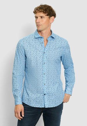 Light blue button-up shirt featuring a floral pattern, long sleeves, and a classic collar, paired with dark jeans.