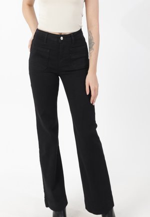 Schwarze, hoch taillierte Schlagjeans mit Fronttaschen aus Denim, ausgestattet mit Knopfverschluss und einem sauberen Saumabschluss.