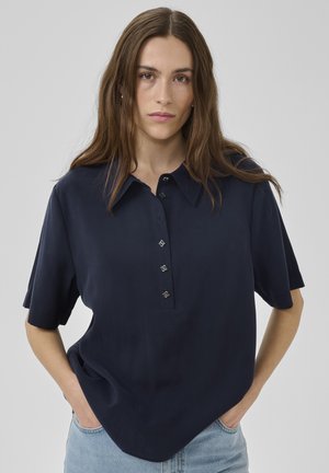 Marineblaue kurzärmelige Bluse mit Knopfleiste und dekorativen Knöpfen. Weicher, glatter Stoff mit lockerem Schnitt und Kragen.