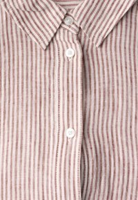 Camicia a righe in rosso chiaro e bianco, con colletto e due bottoni bianchi, realizzata in un tessuto di lino texturizzato.