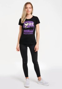 Black cotton t-shirt featuring a graphic print of Woodstock and the text '69 in purple, with a round neckline and short sleeves.