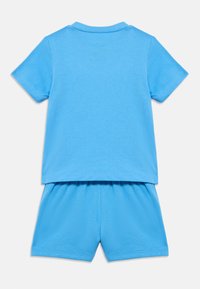 Κοντομάνικο ανοιχτό γαλάζιο μπλουζάκι με στρογγυλή λαιμόκοψη και ταιριαστά σορτς. Απαλό βαμβακερό ύφασμα, άνετη εφαρμογή, χωρίς έντονες μοτίβα ή σχέδια.
