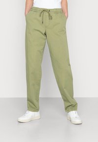 Light olive green casual pants with an elastic waistband and drawstring closure; features two side pockets and a relaxed fit.