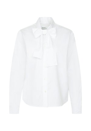 Chemise blanche à manches longues avec boutons sur le devant, ornée d'un grand nœud noué au col, présentant une coupe classique et un design épuré et ajusté.