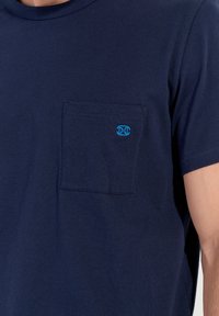 Navy blue cotton t-shirt with short sleeves, featuring a pocket on the left chest with a small blue embroidered logo.