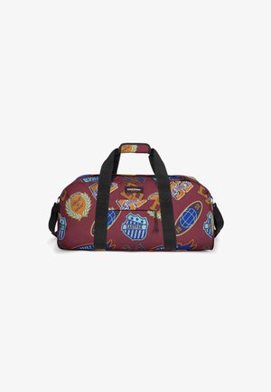 Duffle Bag aus weinrotem Stoff, versehen mit bunten Aufnähern und Logos. Strapazierfähige schwarze Griffe und ein Reißverschlussverschluss. Rechteckige Form.