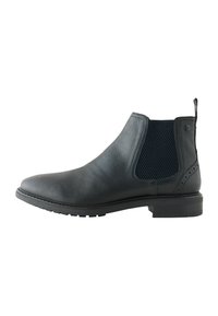 Botín chelsea de cuero negro con paneles laterales de malla elástica, acabado texturizado, punta redondeada y suela de goma duradera con un ligero tacón.