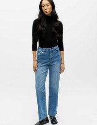 Traperice plave boje visokog struka s ravnim nogavicama, srednje pranje, pet džepova i blago izblijedjele, uparene s crnom bluzom dugih rukava.