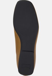 Suela de zapato de cuero marrón con una base de goma negra texturizada, que presenta una forma redondeada y un tacón cuadrado para mayor estabilidad.