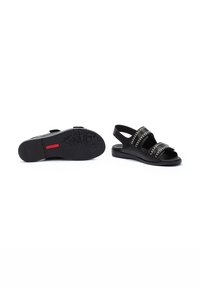 Sandalias negras con dos correas anchas con costuras decorativas, una correa ajustable en el talón y una suela de goma texturizada.